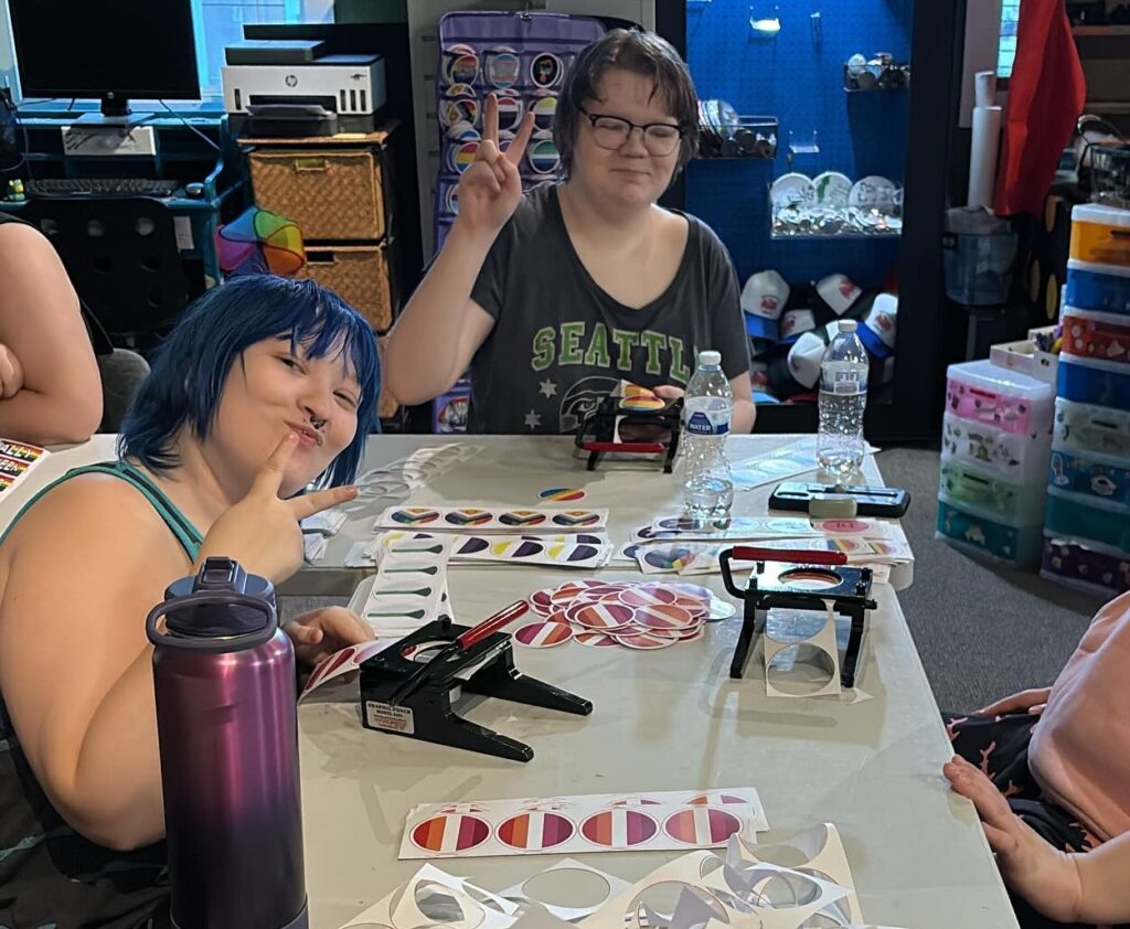 People prepping button circles for a community event.